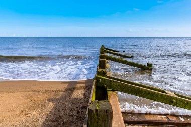 Yazın İngiltere, Skegness sahilinde ufukta görünen bir rüzgar çiftliği manzarası.