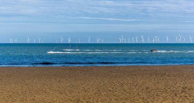 Skegness, İngiltere 'de yaz mevsiminde sahil, deniz ve rüzgar çiftliği