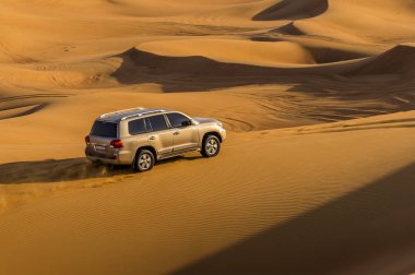 Driving across the red desert at Hatta near Dubai, UAE in springtime clipart