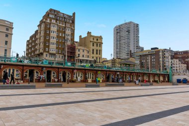 Güneşli bir günde İngiltere 'nin Brighton kentindeki gezinti yolu boyunca esnaf dükkanları