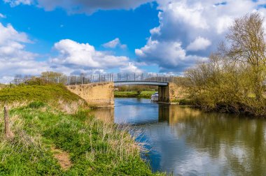 İlkbaharda Thrapston, Northamptonshire 'ın dışındaki Nene Nehri üzerindeki bir köprüye doğru bir manzara.