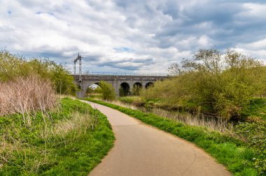 Nene Nehri 'nin nehir kıyısındaki Northampton, İngiltere' deki Far Cotton Demiryolu viyadük hattına doğru uzanan bir manzara.