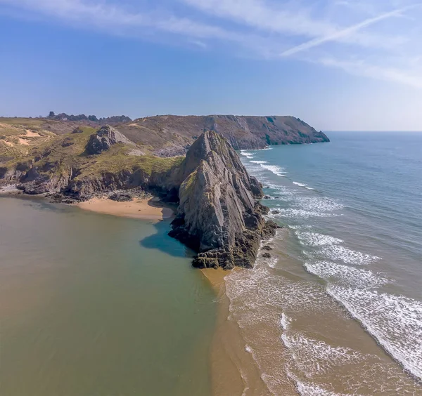 An aerial view along the length of the three cliffs in Three Cliffs Bay, Gower Peninsula, Swansea, South Wales on a sunny day