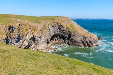 Güney Galler, Pembrokeshire sahilinde kayalık bir koy ve mağara manzarası