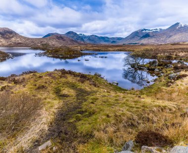 Glencoe, İskoçya yakınlarındaki Loch Ba 'nın sularındaki yansımaların bir yaz günü