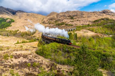 Glenfinnan, İskoçya 'da bir yaz günü viyadük' ten kalkan bir trenin görüntüsü