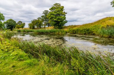 Güneşli bir günde İngiltere 'nin Oundle yakınlarındaki Nene Nehri' ne bir akarsu manzarası