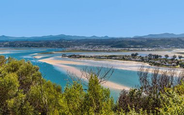 Bahar zamanı Güney Afrika 'da, Knysna nehrindeki eğlence adasının kumları üzerinde West Head burnu manzarası.