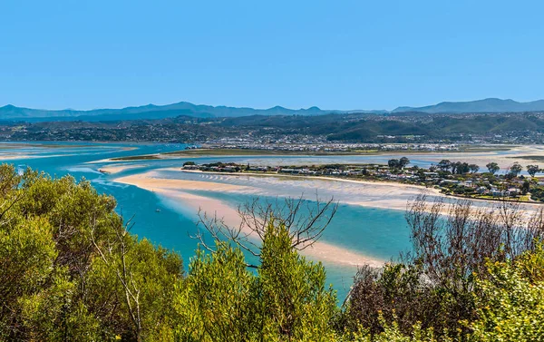 Bahar zamanı Güney Afrika 'da, Knysna nehrindeki eğlence adasının kumları üzerinde West Head burnu manzarası.