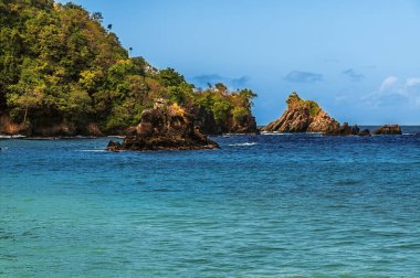 Ocak ayının aydınlık bir gününde Tobago 'daki İngiliz Körfezi girişindeki kayalık adalara yakın çekim