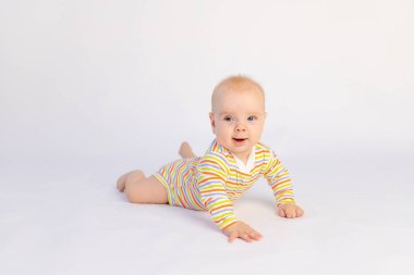 6 aylık gülümseyen küçük bir kız çocuğu, beyaz bir arka planda, parlak bir vücut giysisi içinde, mesaj için boş bir alanda yatıyor. Sağlıklı mutlu bir çocuk..