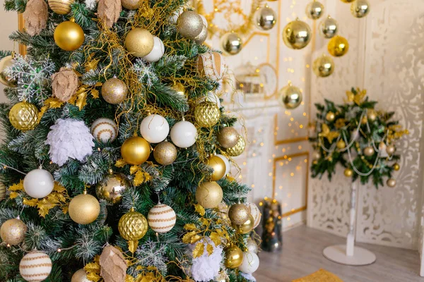 new year\'s interior of the house in gold color, Christmas tree with balloons and garland