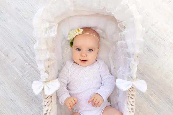 穿着白色紧身衣的可爱的6个月大的女婴躺在漂亮的婴儿床里 — 图库照片