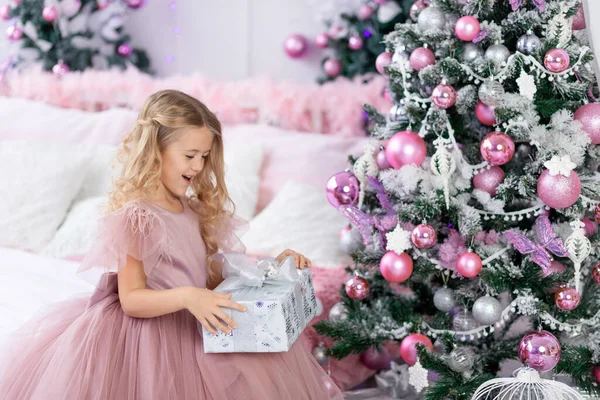 Menina Descompacta Presente Natal Árvore Natal Belo Vestido Cor Rosa — Fotografia de Stock