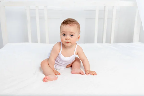 婴儿正坐在一间明亮房间的婴儿床里 — 图库照片