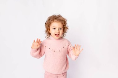 Beyaz arka planda pembe kışlık elbiseli küçük kız sevinç çığlıkları, mesaj atmak için yer