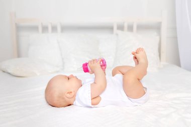 Bebeğin yatakta biberon emmesi, bebek maması konsepti