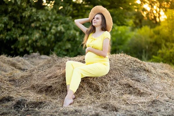 Una Mujer Embarazada Con Ropa Oscura Sombrero Sienta Campo Sobre —  Fotos de Stock