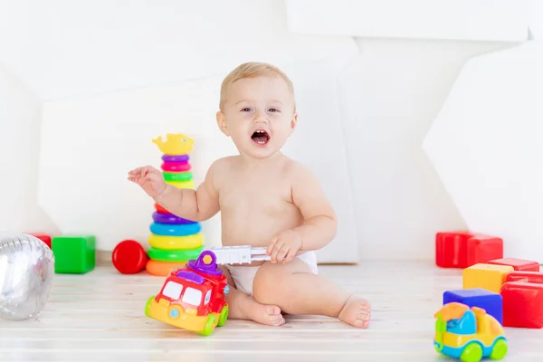 Uma Criança Pequena Menino Seis Meses Brinca Com Brinquedos Brilhantes — Fotografia de Stock
