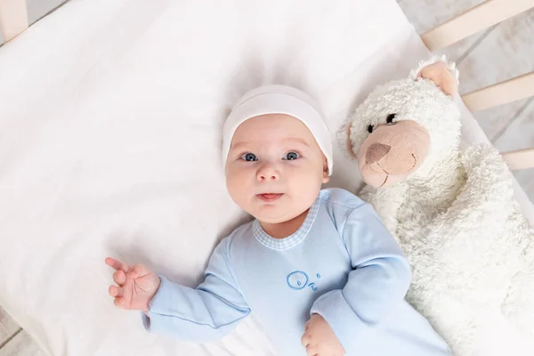 ベビー クリブかわいい赤ちゃんの肖像3ヶ月のベビー クリブでテディベアのおもちゃと子供と誕生のコンセプト — ストック写真