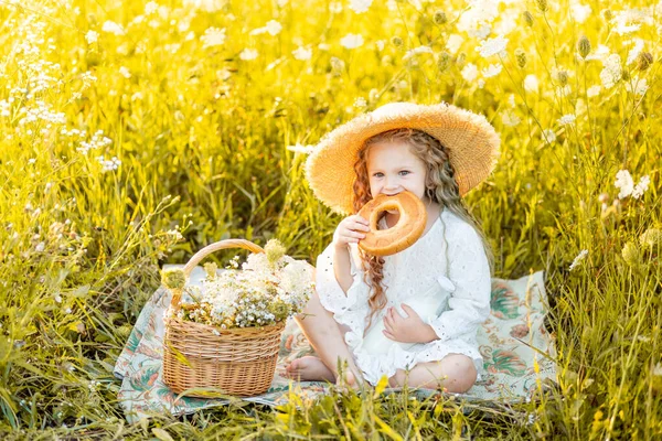 Όμορφο Μικρό Κορίτσι Κάθεται Ένα Ψάθινο Καπέλο Ένα Κίτρινο Πεδίο — Φωτογραφία Αρχείου