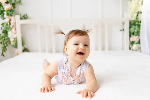 6个月的小女孩 穿着花边紧身衣 笑着爬到一个明亮美丽的房间里 — 图库照片