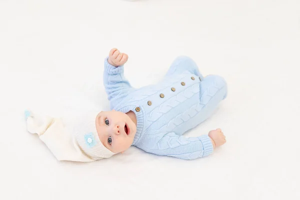 baby on the bed among the cloud pillows. Textiles and bedding for children.