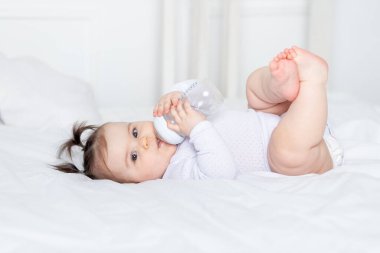 Evdeki yatakta şişesi olan bebek maması konsepti.