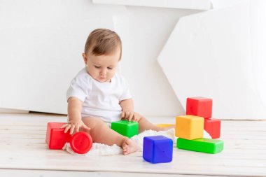 Erkek bebek evde küp ve piramitlerle oynuyor. Oyun konsepti ve çocukların gelişimi.