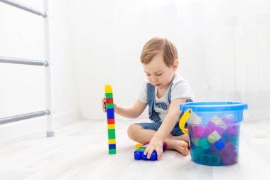 Evde inşaatçısı olan bir çocuk, yakışıklı bir çocuk siyahi bir inşaatçıyla oynar veya koleksiyon yapar.