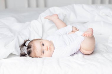 Bebek ayaklarıyla yatakta yatıyordu. Mutlu bir aile ve çocuk kavramı.