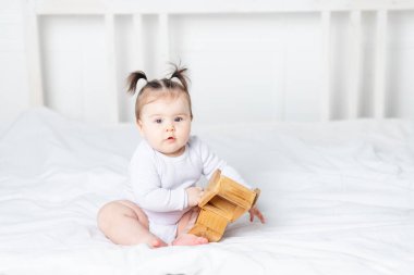bebek evdeki yatakta tahta oyuncak daktiloyla oynuyor, oyun konsepti ve çocukların gelişimi