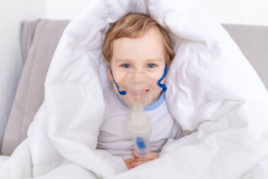 Spreyli hasta çocuk evde boğazını tedavi ediyor. Sağlık ve solunum tedavisi kavramı.