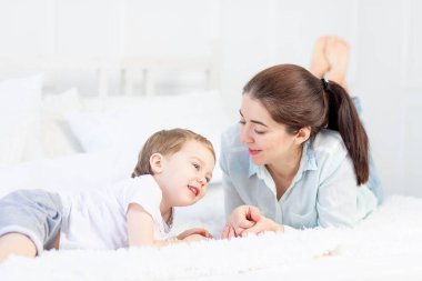 Anne ve bebek evde yatakta oynuyorlar. Aile ve ebeveyn-çocuk ilişkisi kavramı.