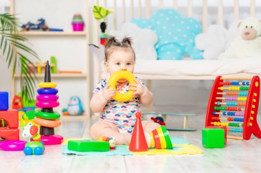 Bebek evde, çocuk odasında oyun oynuyor. Küçük çocuklar için oyuncaklar. Eğitici oyuncakları olan bir çocuk. Erken gelişme