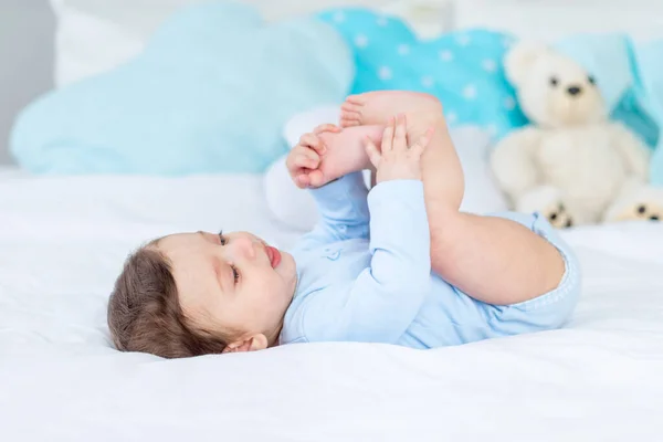 Baby Boy Bed Blue Bodysuit Playing His Feet Happy Healthy — Stok fotoğraf