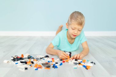 bir çocuk mavi arka planda bir ev inşaatçısıyla oynar