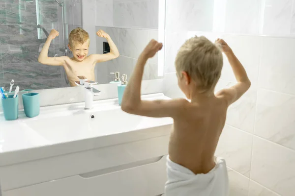 Jongen Toont Zijn Biceps Maakt Een Gezicht Voorkant Van Badkamer — Stockfoto