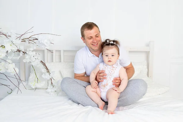 Mutlu Bir Baba Kollarında Küçük Bir Kız Beyaz Bir Yatak — Stok fotoğraf