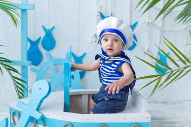 Denizci yeleğinde bir gemiyle deniz bölgesinde bebek, yaz ve seyahat kavramı.