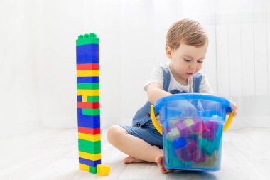 Evde inşaatçısı olan bir çocuk, yakışıklı bir çocuk siyahi bir inşaatçıyla oynar veya koleksiyon yapar.