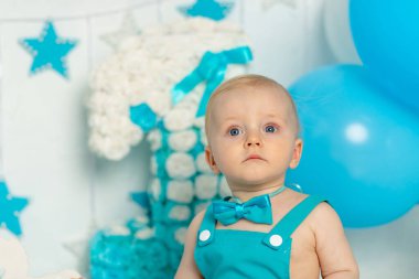 Doğum günü partisi dekorunda bir erkek bebeğin portresi. Bir yaşında, balonlu, bayramlı ve dekorlu.
