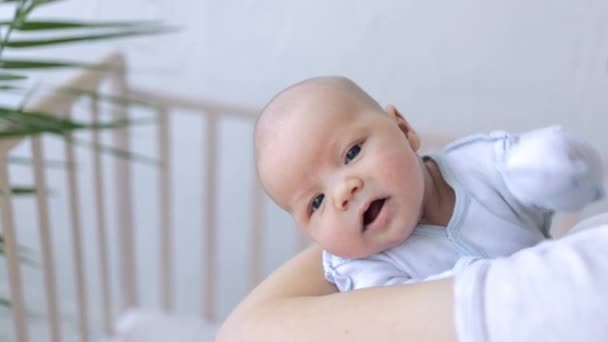 Grappig baby pasgeboren baby jongen in moeders armen opent zijn mond op zoek naar een tepel of borst, vragen om voedsel — Stockvideo