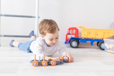 Erkek bebek evde tahta oyuncaklarla oynuyor.