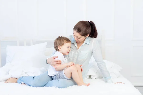 Anne ve bebeğin evde yatakta konuşması, ebeveynler ve çocuklar arasındaki ilişki kavramı. — Stok fotoğraf