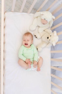 Yatak odasında ipi olan, beşiğinde ağlayan bir bebek.