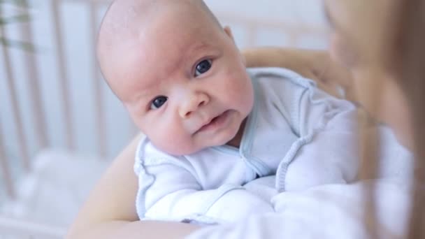 Маленький новорожденный мальчик в руках матерей в детской с открытыми глазами, крупным планом — стоковое видео