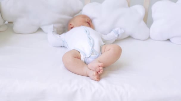 Nohy novorozence zblízka na bílé posteli doma v kolébce — Stock video