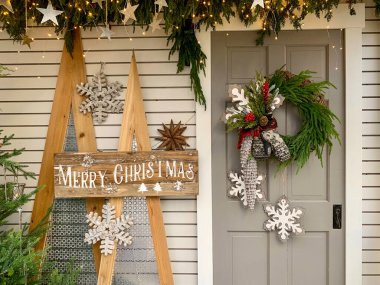 Kapısında süslemeler olan Noel çelengi.