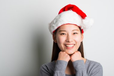 Genç Asyalı kadın üzerinde beyaz izole Noel şapka ile.